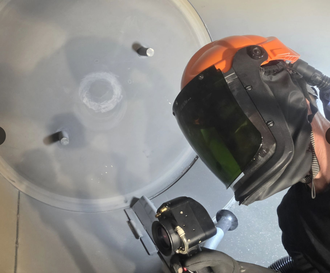 Opérateur GDS LASER équipé d’une protection faciale pendant le nettoyage laser de l’intérieur d’un four industriel